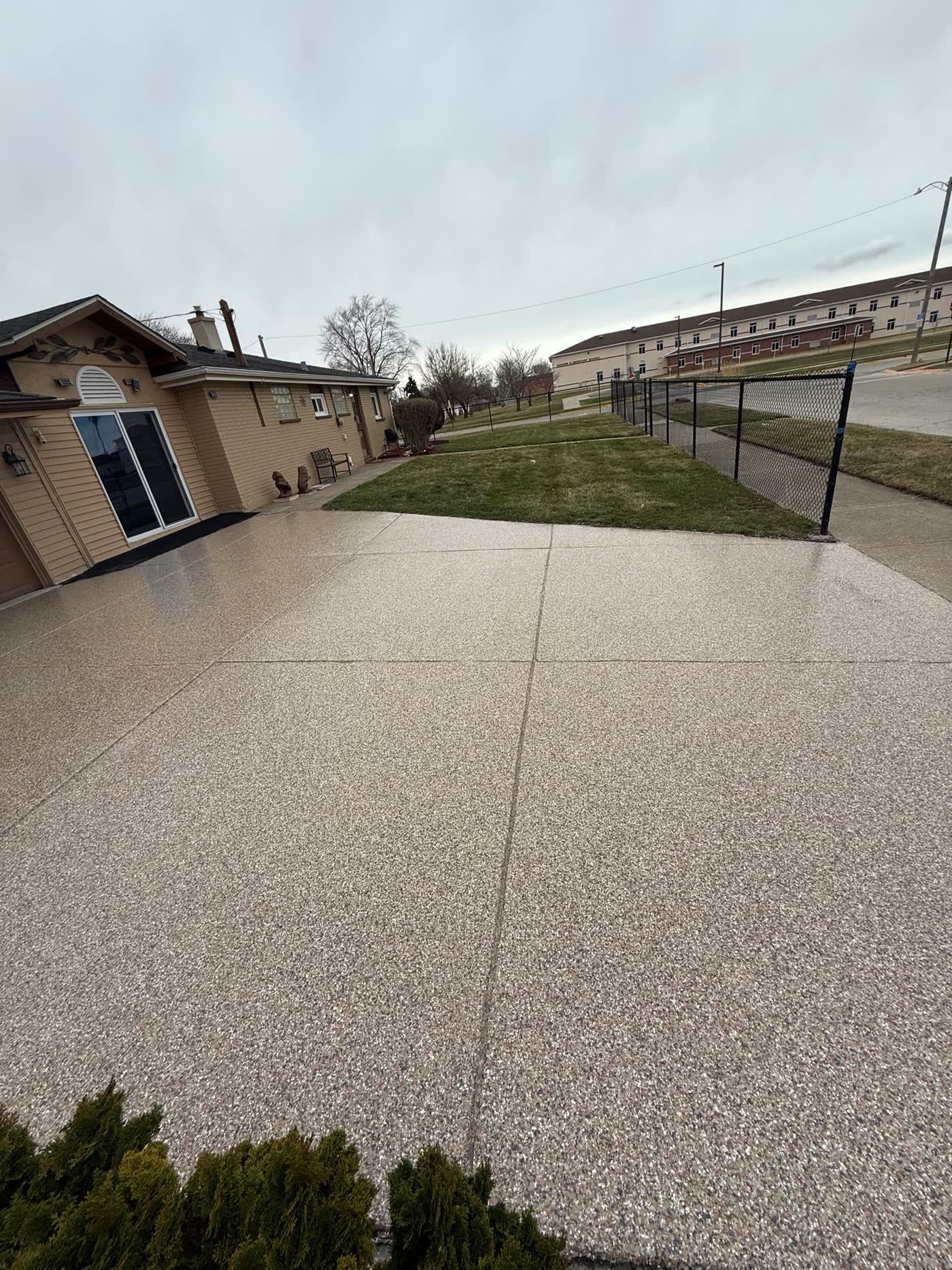Tan flake epoxy coating on a residential driveway